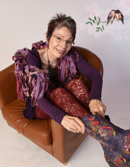 Anne Sagendorph-Moon sitting in chair purple boots